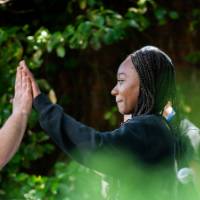 Student high fiving videographer after being interviewed about a Groundswell Project.
